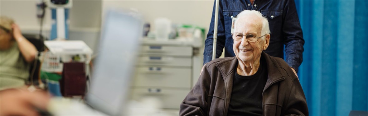 Patient in a wheelchair coming to hospital with his carer